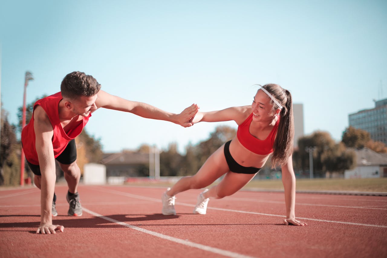 Man and woman high-fiving while in a plank.
